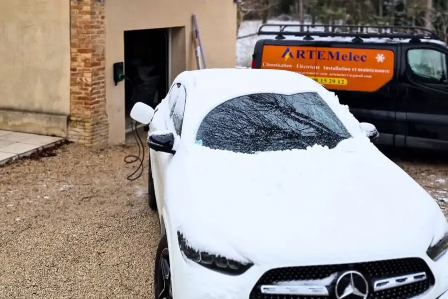 Voiture électrique en charge sous la neige devant le fourgon ARTEMELEC