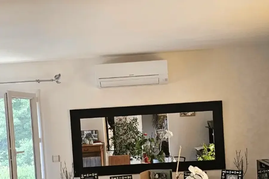 Unité murale d’une pompe à chaleur air-air posée en hauteur dans une salle à manger