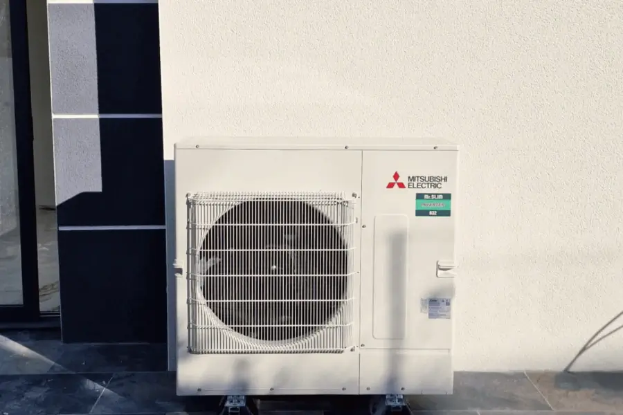 Unité extérieure de pompe à chaleur Mitsubishi Electric posée le long d’une façade