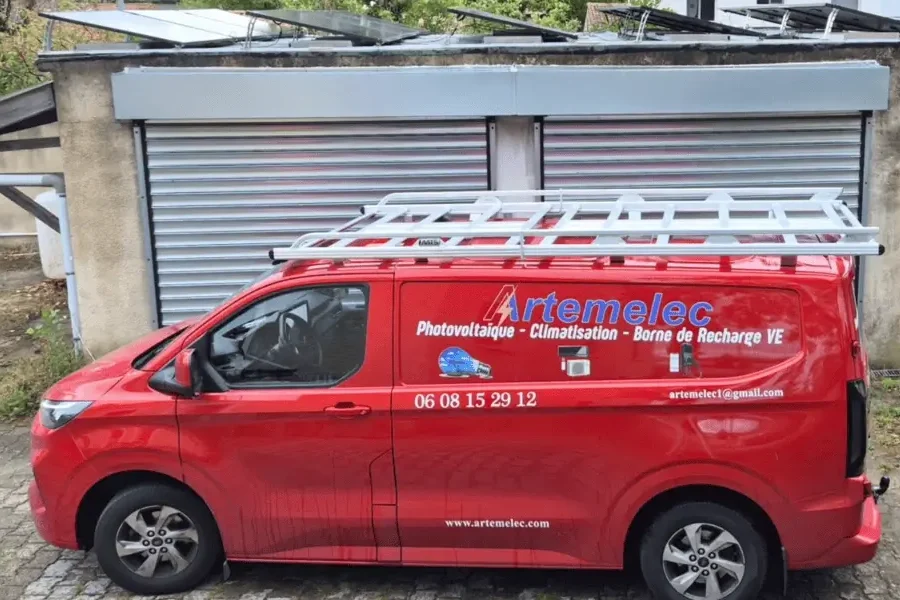 Camionnette ARTEMELEC floquée photovoltaïque, climatisation et borne de recharge, devant un local à Valence